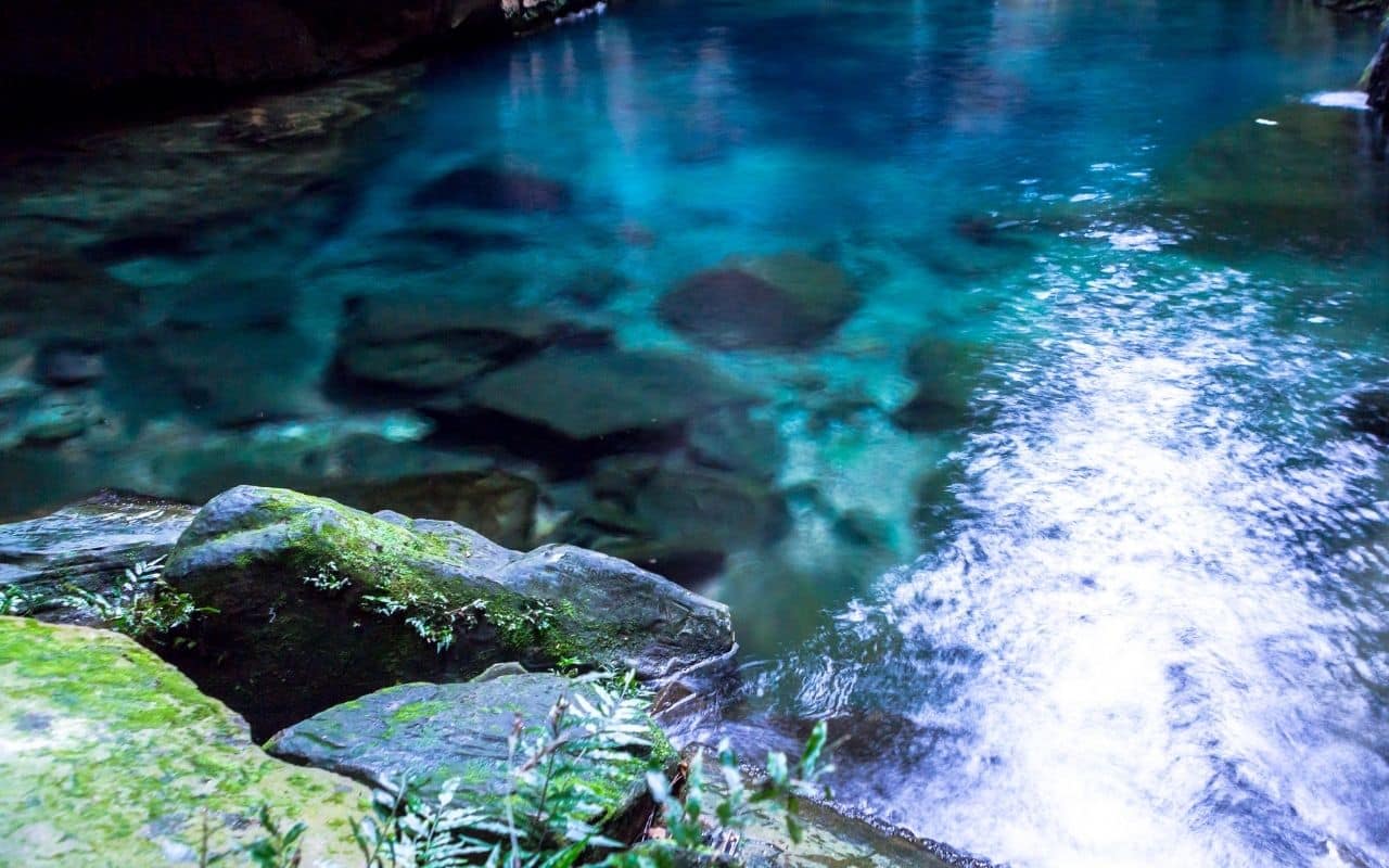 A fast-flowing stream settling into a calm, still pool, symbolising emotional regulation in adhd and binge eating
