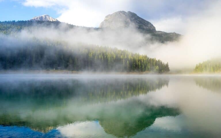 Morning mist clearing over a calm mountain lake, symbolising clarity around is body dysmorphia a mental illness