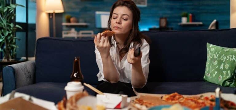 lady with adhd binge eating while watching tv