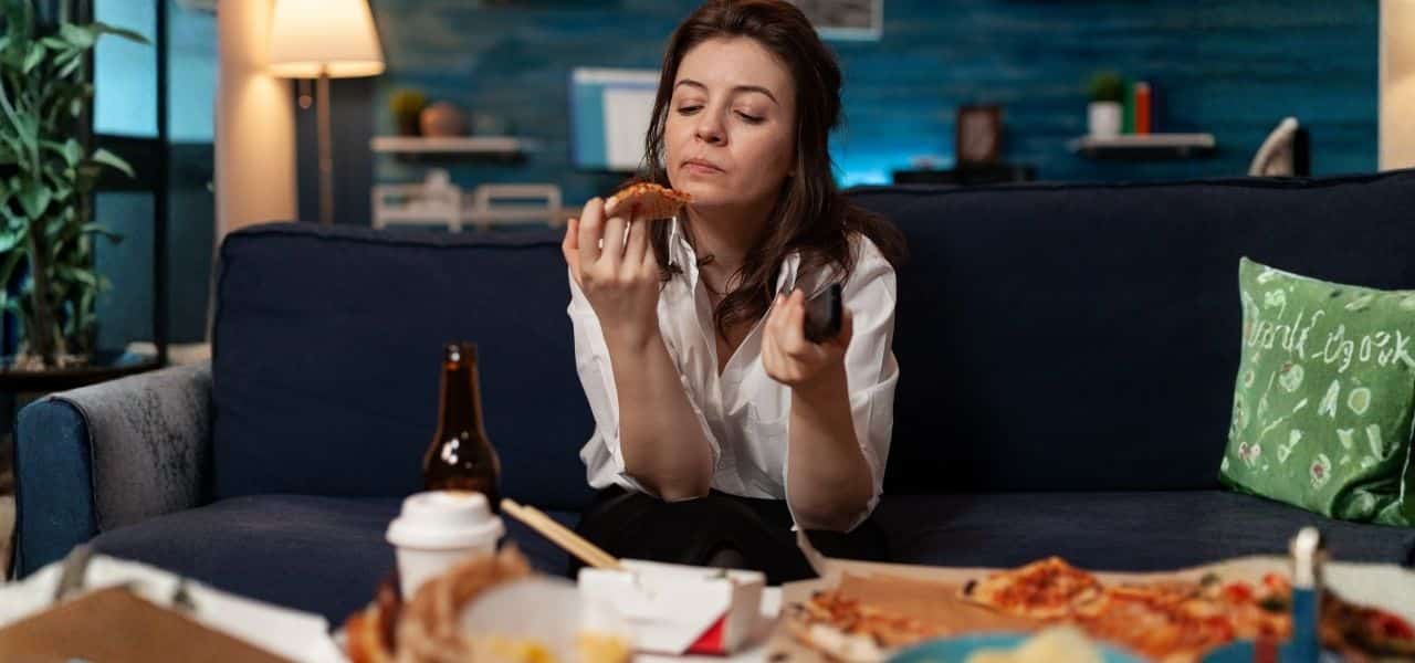 lady with adhd binge eating while watching tv