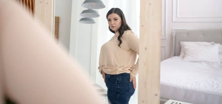 how to help someone with body dysmorphia - lady looking in the mirror
