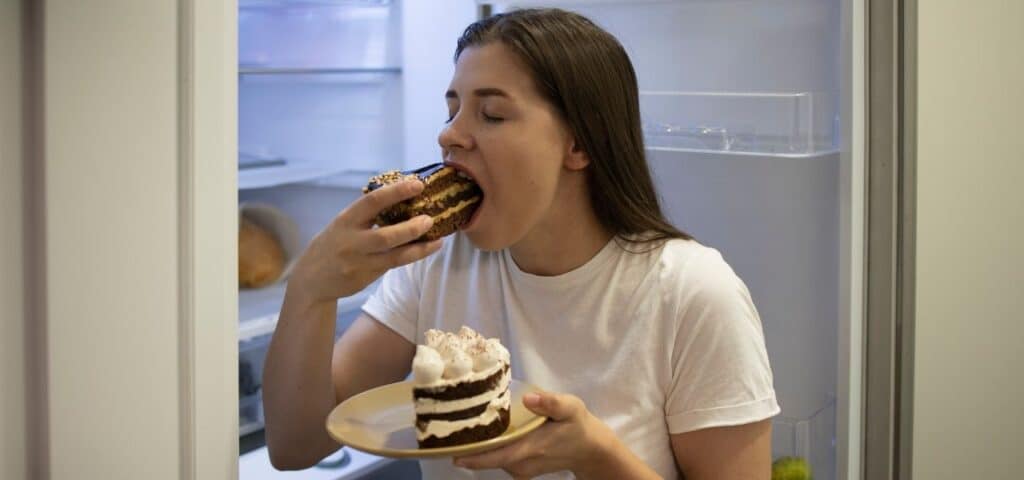 physical signs of bulimia nervosa - woman bingeing on cake