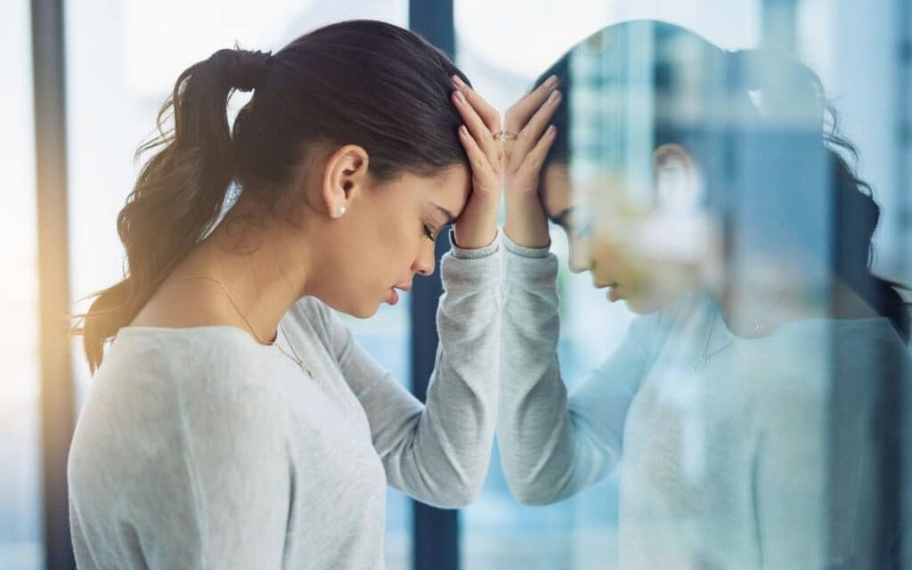 how to deal with body dysmorphia - lady with her head against a window